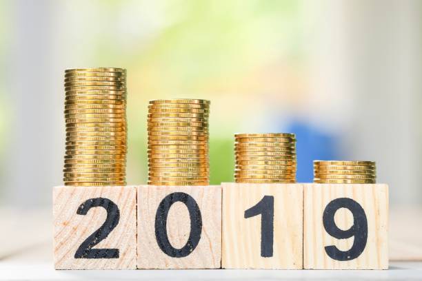 istock Growth of coins stack and wood blocks number 2019. 1082766608