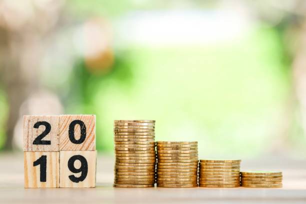 istock Growth of coins stack and wood blocks number 2019. 1082766636