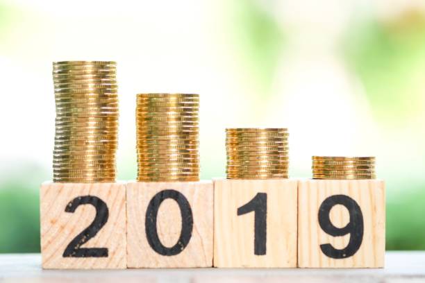 istock Growth of coins stack and wood blocks number 2019. 1082766646
