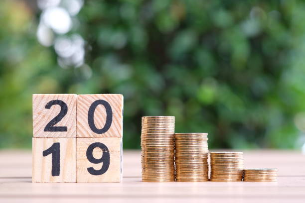 istock Growth of coins stack and wood blocks number 2019. 1082766662