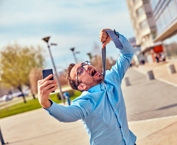 istock Funny businessman getting angry while using smartphone outdoors. 1082774442