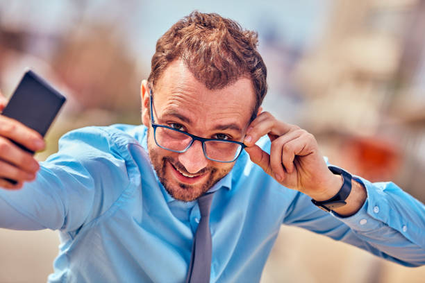 istock Funny businessman with thumbs up while using smartphone outdoors. 1082776952