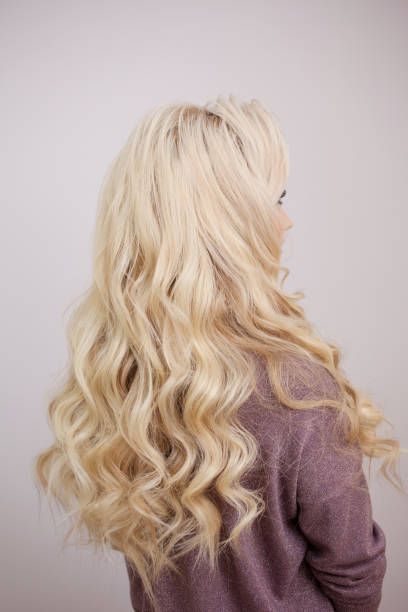 istock Back view of blonde with long luxurious curls. 1082790726