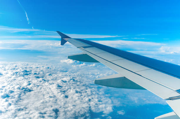 istock Wing of aircraft flying above the clouds 1082800636