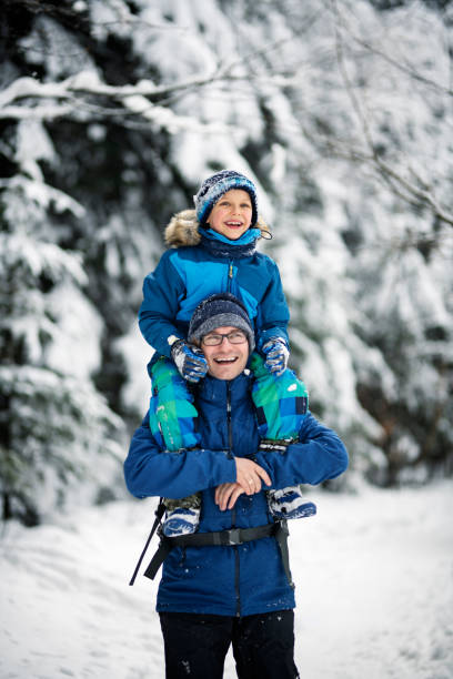 istock Father and son enjoying winter walk in forest. 1082806380