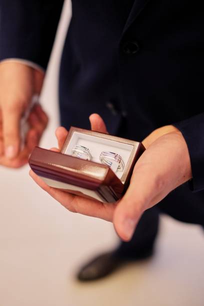 istock Man's hands holding a white box with a wedding rings 1082826594