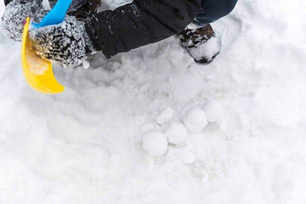 istock teenager's hands. sculpt snowballs. 1082829826