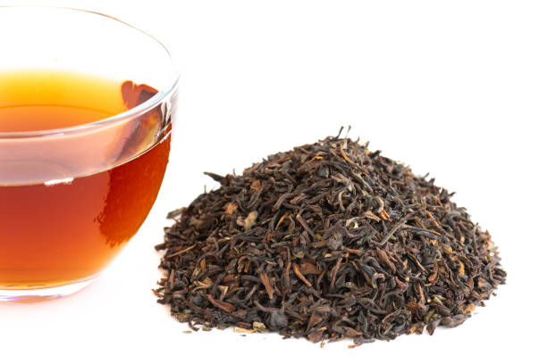 istock Cup of tea, stacked dried tea leaves isolated on white background 1082830470