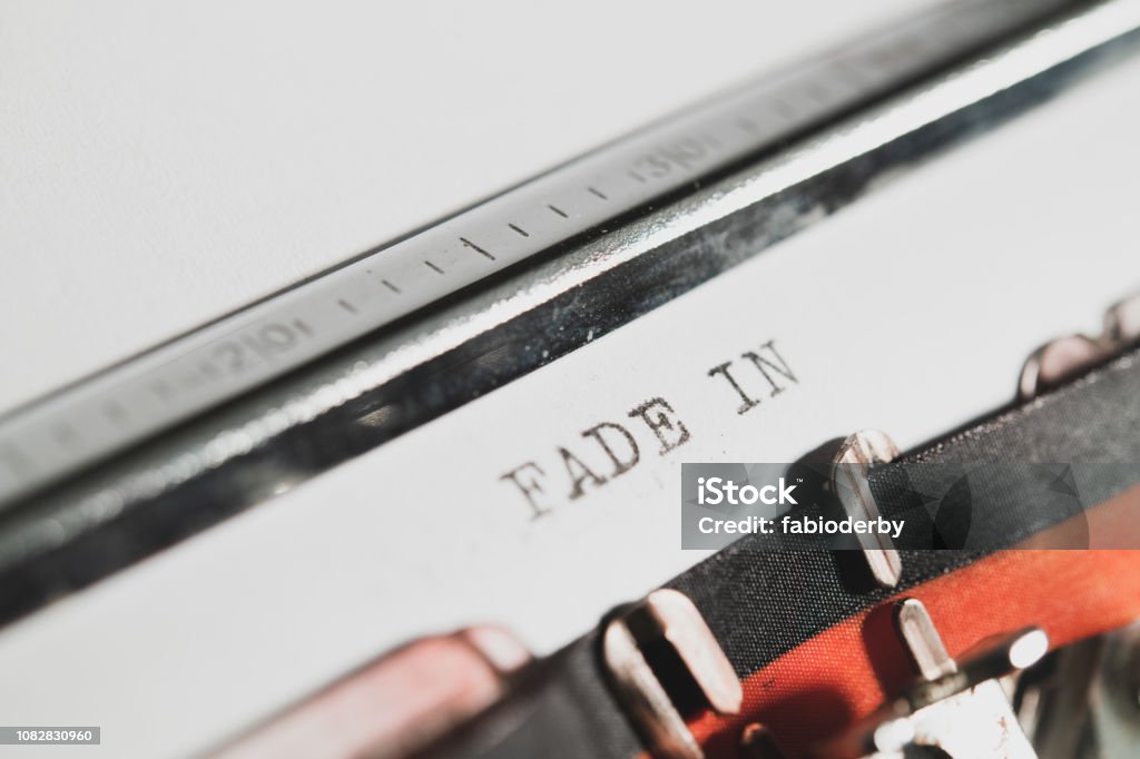 Typewriter vintage text "fade in" "fade in" text on white paper classic movie script opening close up Film Script Stock Photo