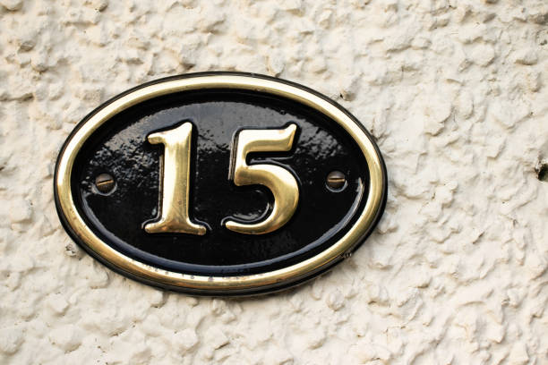 istock Gold Number 15 on cream pebble dash wall 1082833478