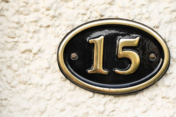 istock Gold Number 15 on cream pebble dash wall 1082833568