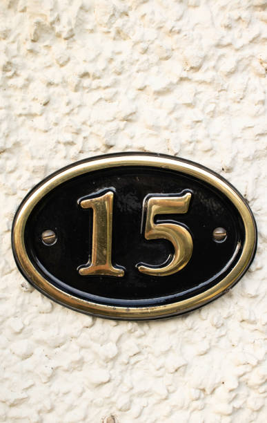 istock Gold Number 15 on cream pebble dash wall 1082833578