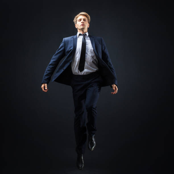 biznesmen na ciemnym tle. skok w nieznane, ambitny projekt koncepcyjny biznesu. - men businessman jumping levitation zdjęcia i obrazy z banku zdjęć