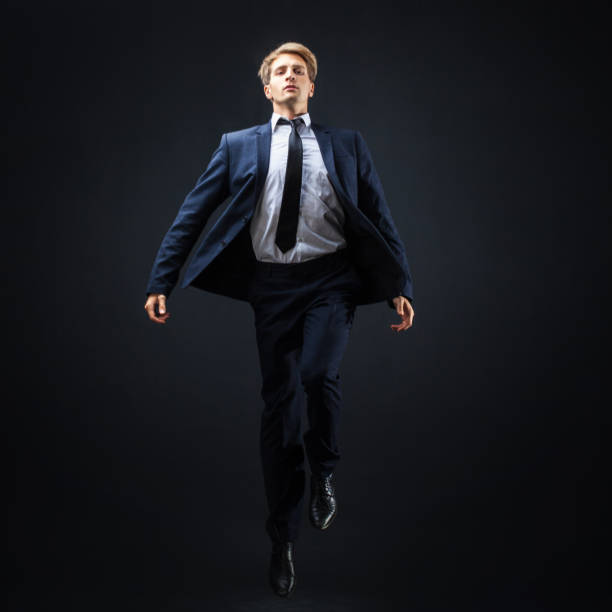 businessman on a dark background. a leap into the unknown, an ambitious business concept project. - men businessman jumping levitation imagens e fotografias de stock