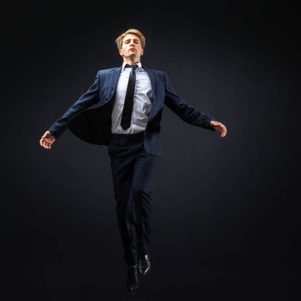 暗い背景に実業家。野心的な事業コンセプト、未知の世界への飛躍。 - men businessman jumping levitation ストックフォトと画像