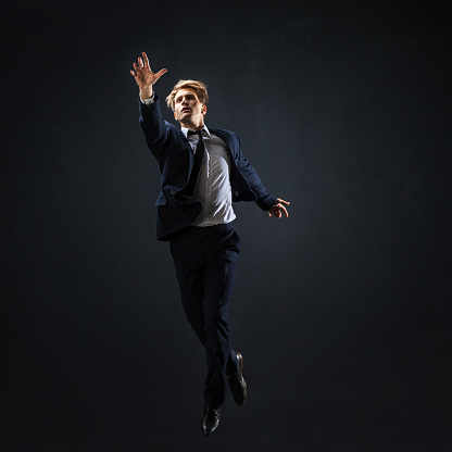 Businessman jumping up. Young man in business suit seeking higher ambition concept