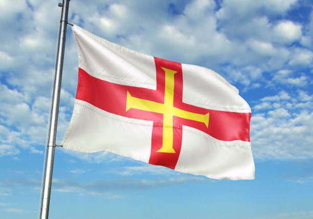 istock Guernsey flag waving cloudy sky background 1082843050