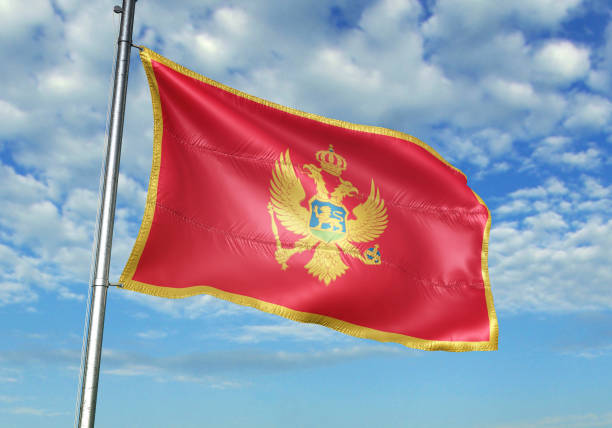istock Montenegro flag waving cloudy sky background 1082844124