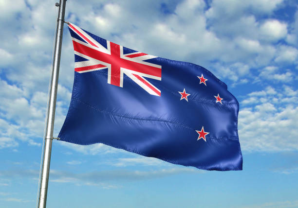 istock New Zealand flag waving cloudy sky background 1082844242