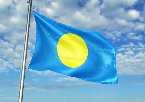 istock Palau flag waving cloudy sky background 1082844378