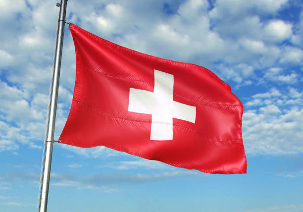istock Switzerland flag waving cloudy sky background 1082847752