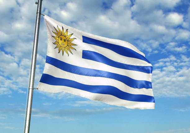 istock Uruguay flag waving cloudy sky background 1082847822