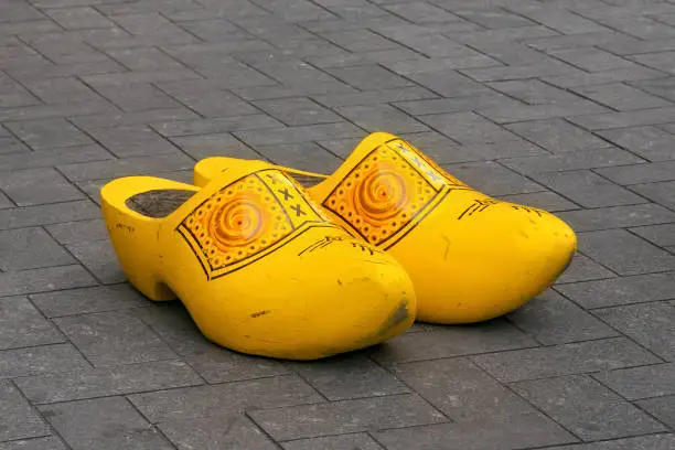Photo of Traditional Dutch wooden big klomps (shoes also known as clogs or klompen) on the pavement  in center of Amsterdam.
