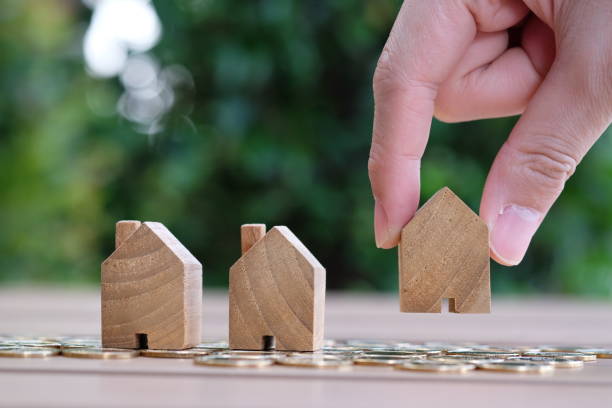 istock Hand pick up wooden house. 1082866682