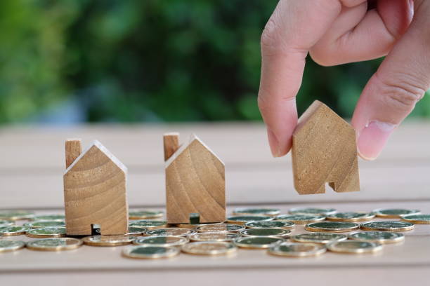 istock Hand pick up wooden house. 1082866820