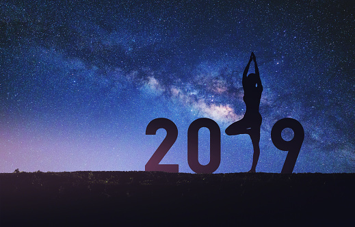 New year 2019 concept Silhouette young happy woman yoga with star and milky way sky background at night