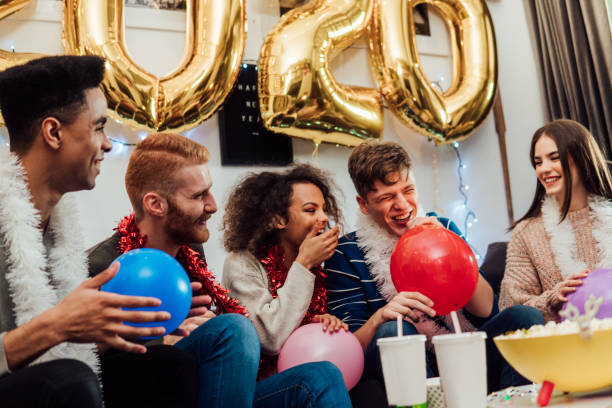 istock Young people blowing balloons 1082880636