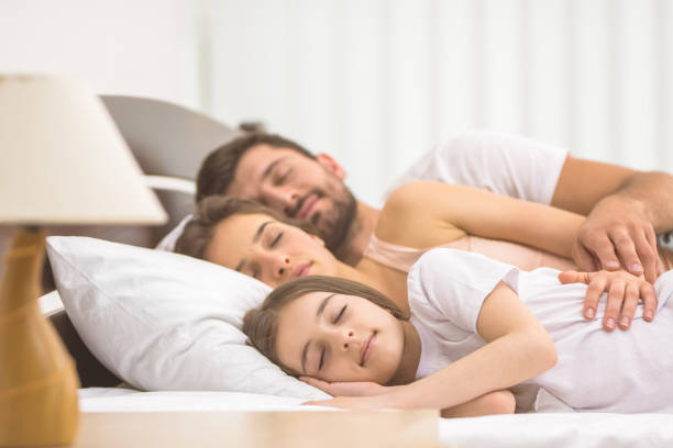 istock The happy family sleeping on the bed 1082883918
