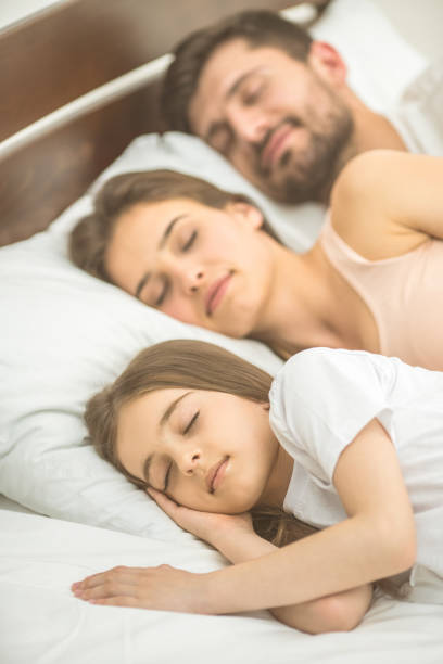 istock The family sleeping on the comfortable bed 1082886696