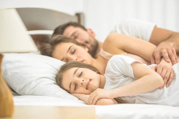 istock The daughter and parents sleeping in the comfortable bed 1082886766