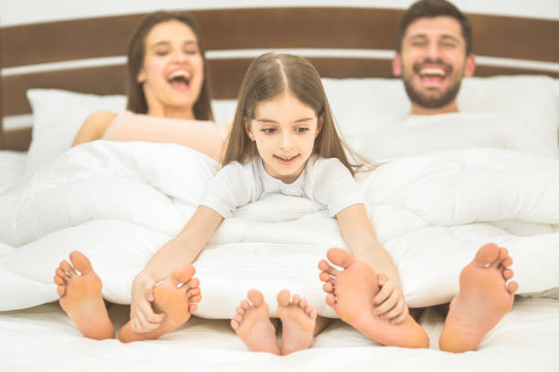 The little girl fun near parents in the bed The little girl fun near parents in the bed bed human foot couple two parent family stock pictures, royalty-free photos & images