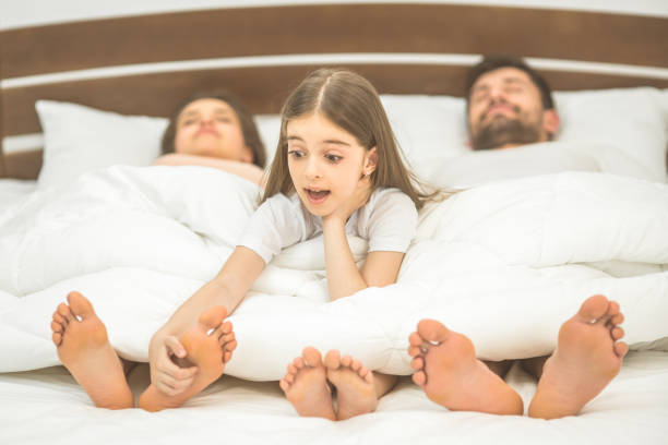 The little girl fun near parents in the bed The little girl fun near parents in the bed bed human foot couple two parent family stock pictures, royalty-free photos & images