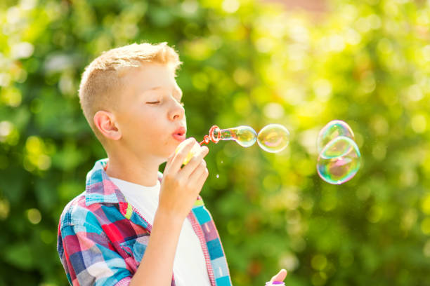 istock Portrait of a young boy blowing soap bubbles 1082906710