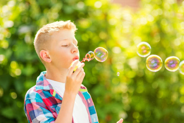 istock Portrait of a young boy blowing soap bubbles 1082906712