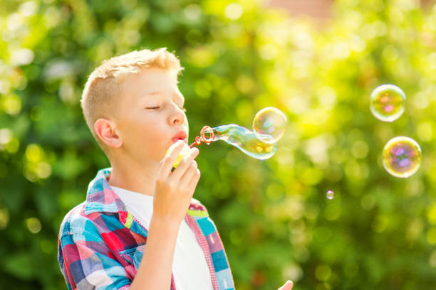istock Portrait of a young boy blowing soap bubbles 1082906728