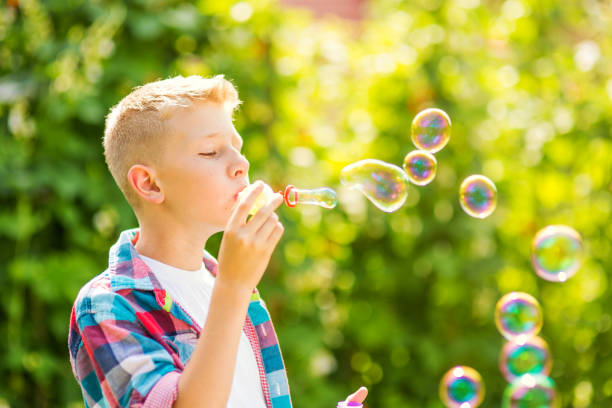 istock Portrait of a young boy blowing soap bubbles 1082906792