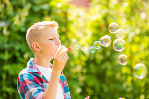 istock Portrait of a young boy blowing soap bubbles 1082906900