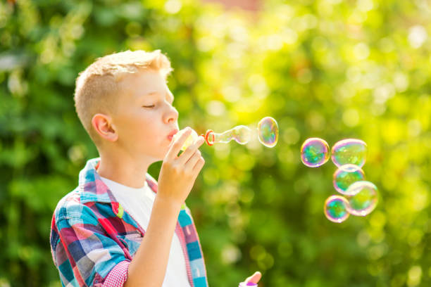 istock Portrait of a young boy blowing soap bubbles 1082906966