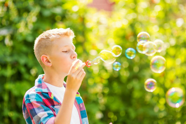 istock Portrait of a young boy blowing soap bubbles 1082907028