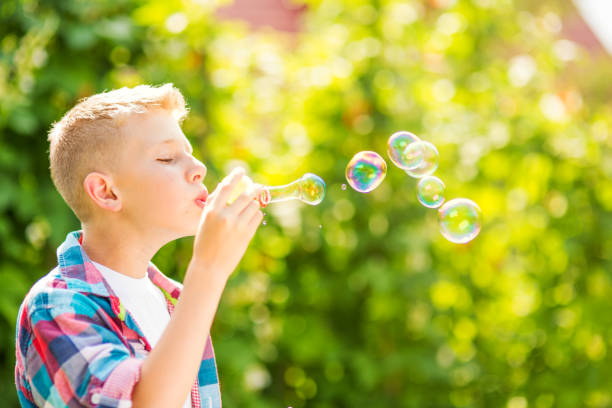 istock Portrait of a young boy blowing soap bubbles 1082907034