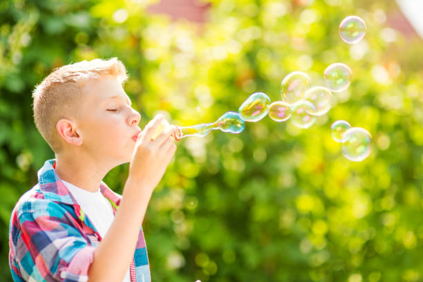 istock Portrait of a young boy blowing soap bubbles 1082907036