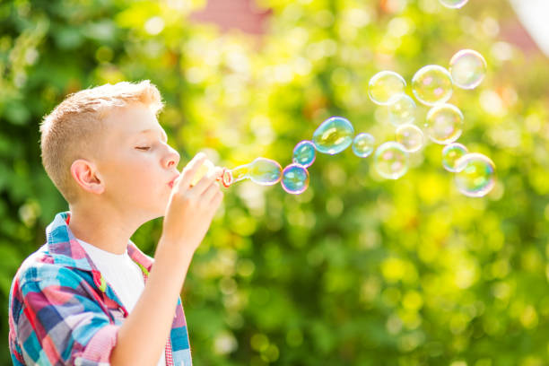 istock Portrait of a young boy blowing soap bubbles 1082907042