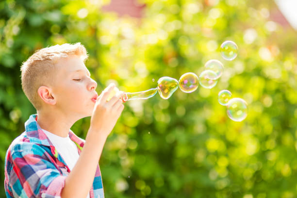 istock Portrait of a young boy blowing soap bubbles 1082907080