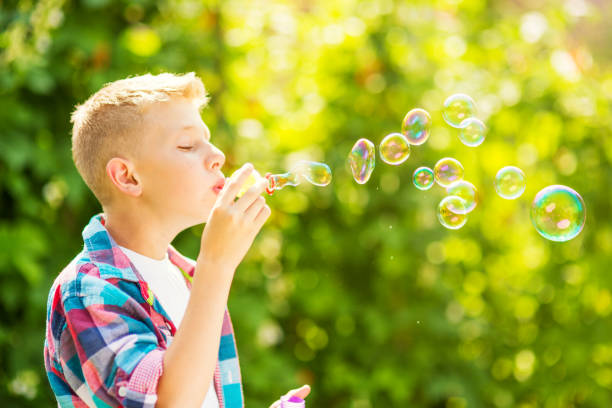istock Portrait of a young boy blowing soap bubbles 1082907150