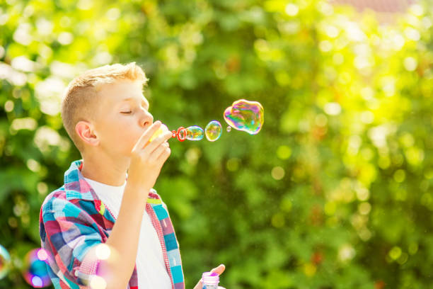 istock Portrait of a young boy blowing soap bubbles 1082907162