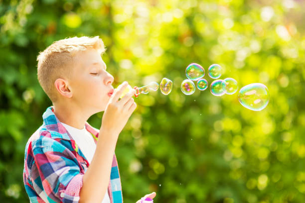 istock Portrait of a young boy blowing soap bubbles 1082907194